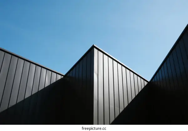 Geometric Black Building Facades Against Clear Blue Sky