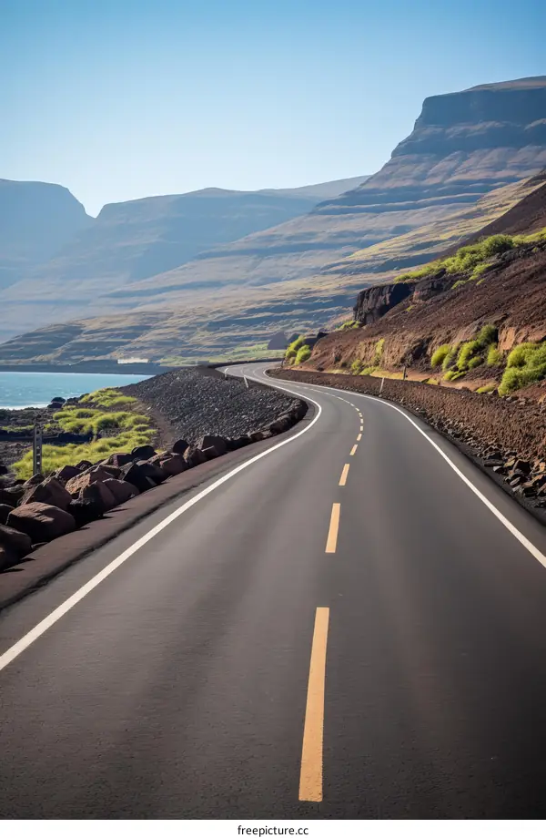 Curving Road along the Coastline with Rocky Mountains in the Distance