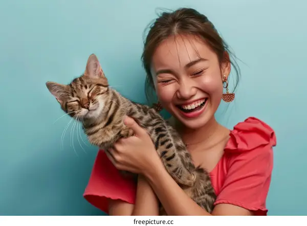 Laughing Asian woman hugging a cat