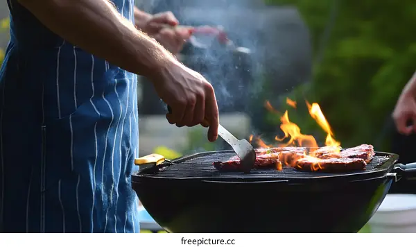 Man Grilling Food On BBQ In Backyard