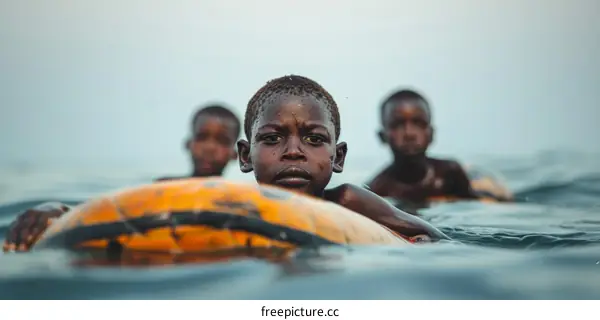 Three African children swimming in the water