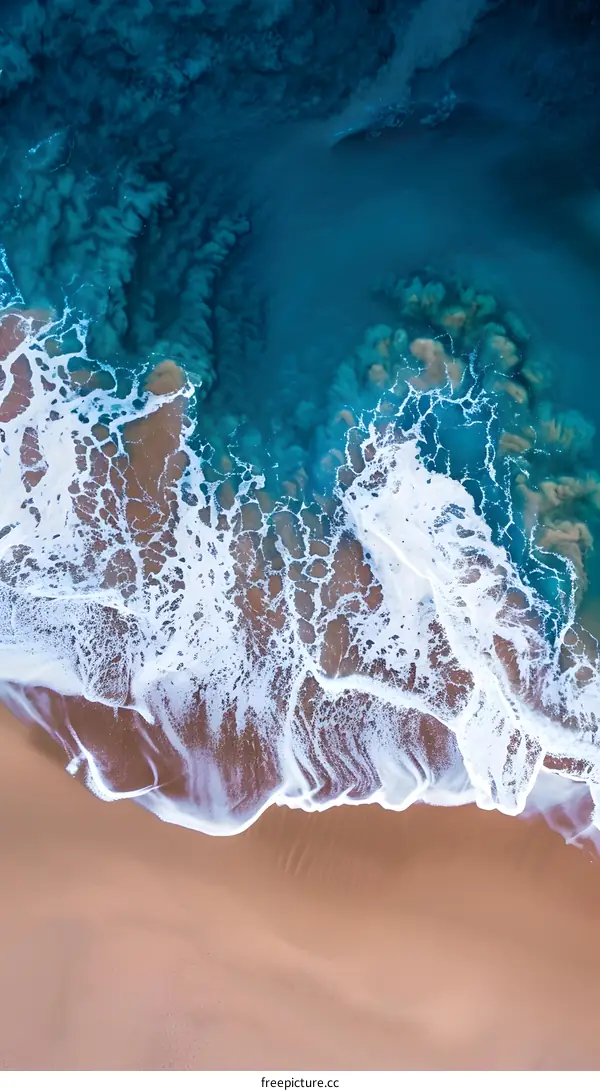 Aerial View Of Ocean Waves Crashing On Sandy Beach