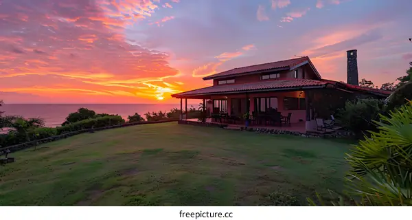 Sunset View from Oceanfront House with Lush Green Grass