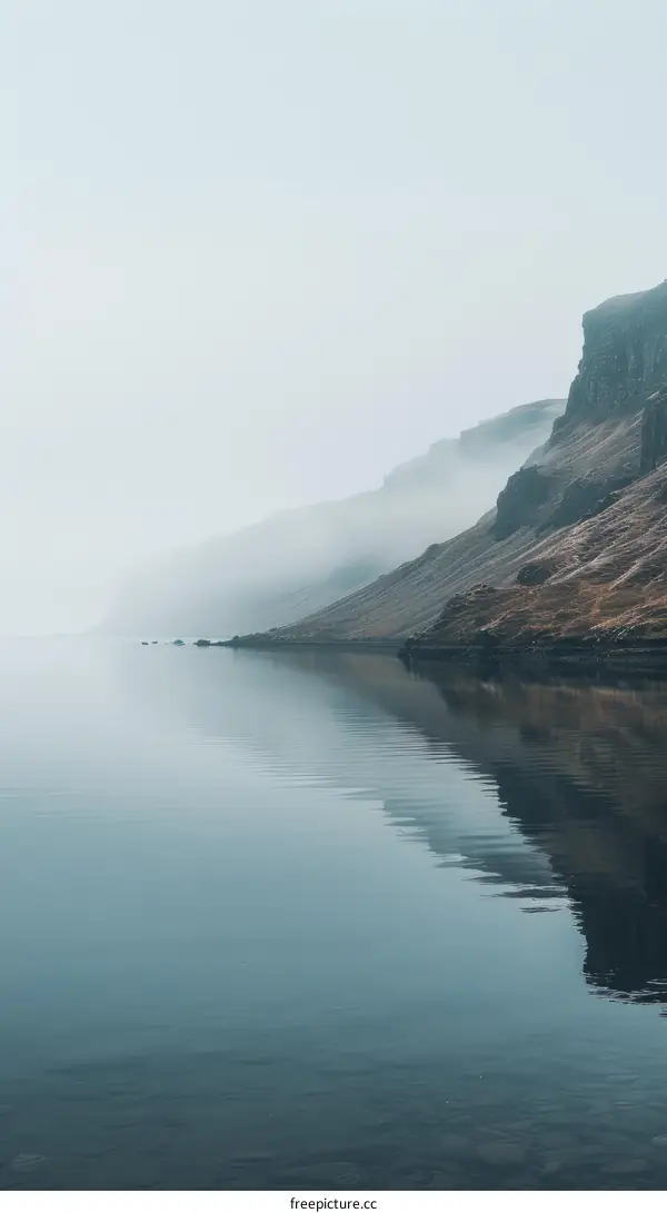 Misty mountains and calm fjord in the morning