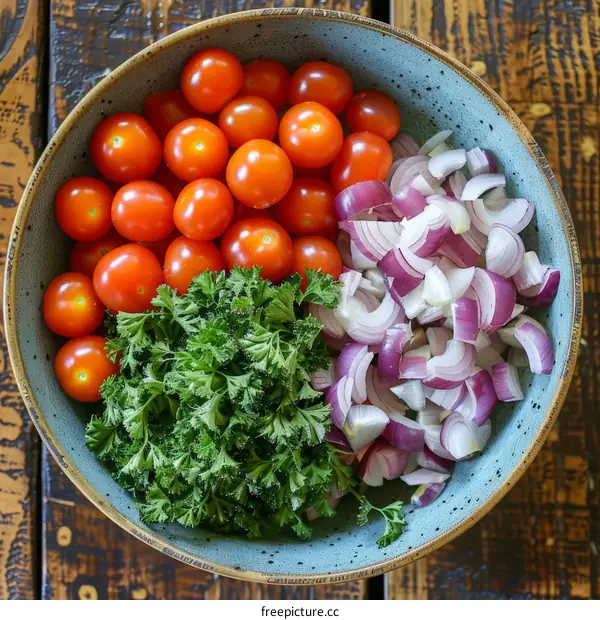 Fresh vegetables including tomatoes, red onions, and parsley in a blue bowl