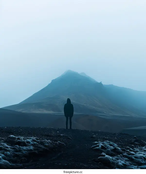 alone man standing on the peak of a mountain