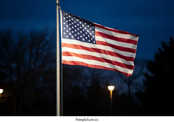 A large American flag flying at night