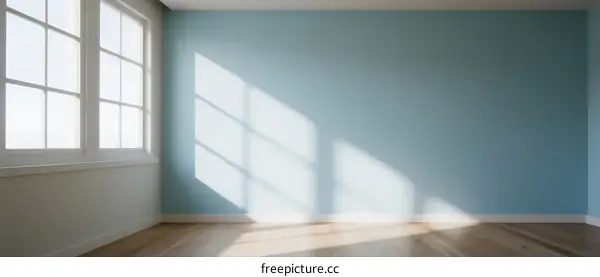 Bright and empty room with light blue wall and wooden floor