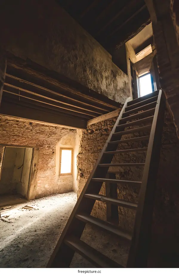 Old Wooden Ladder Leading Up to a Light Filled Window in an Abandoned Building