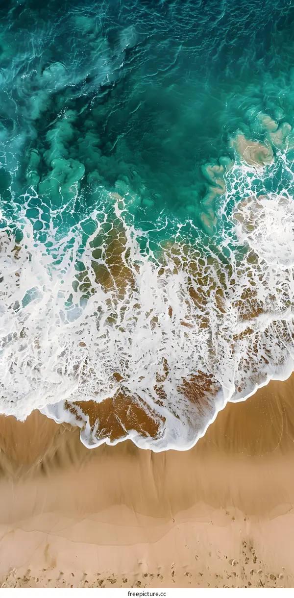 Aerial View of Ocean Waves Crashing on Sandy Beach