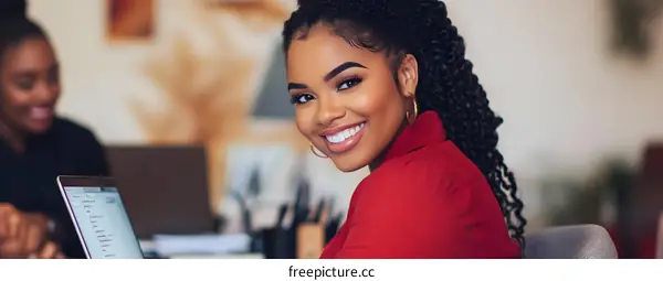 Smiling Businesswoman Working On Laptop Computer In Office
