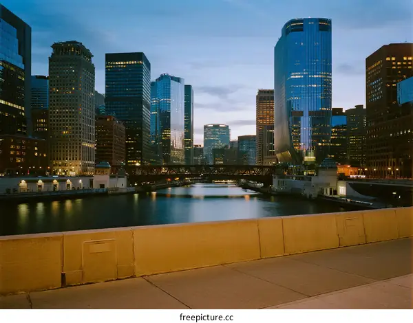 City skyline with tall buildings and a river at dusk