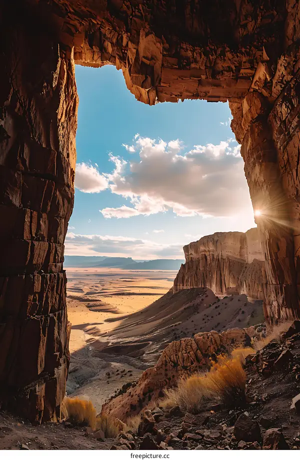 Sun Shining Through Cave Opening Over Canyon Landscape