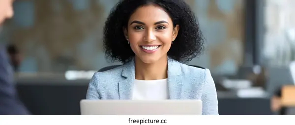 Smiling Businesswoman Working on Laptop in Office