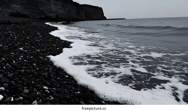 Black Pebbly Beach Meets the Sea