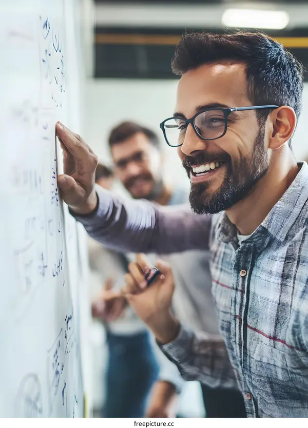 Smiling Man Pointing at Whiteboard During Brainstorming Session