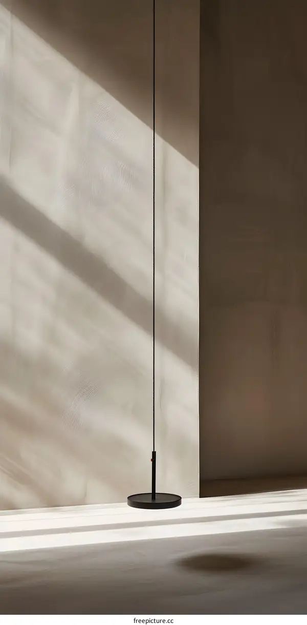 Black Floor Lamp on Beige Wall with Light Shadow