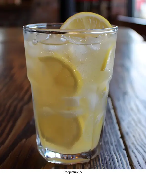 Refreshing Iced Lemon Drink in Glass on Wooden Table