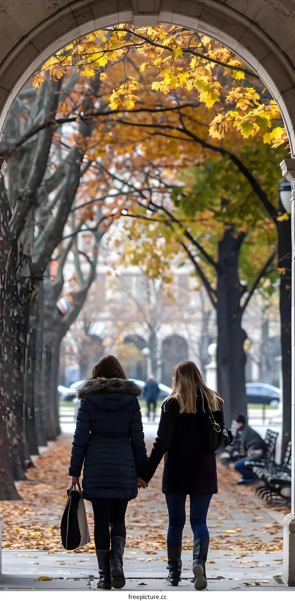 Two Women Walking Through Autumn Archway