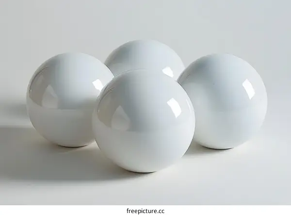 Four white spheres on a white surface