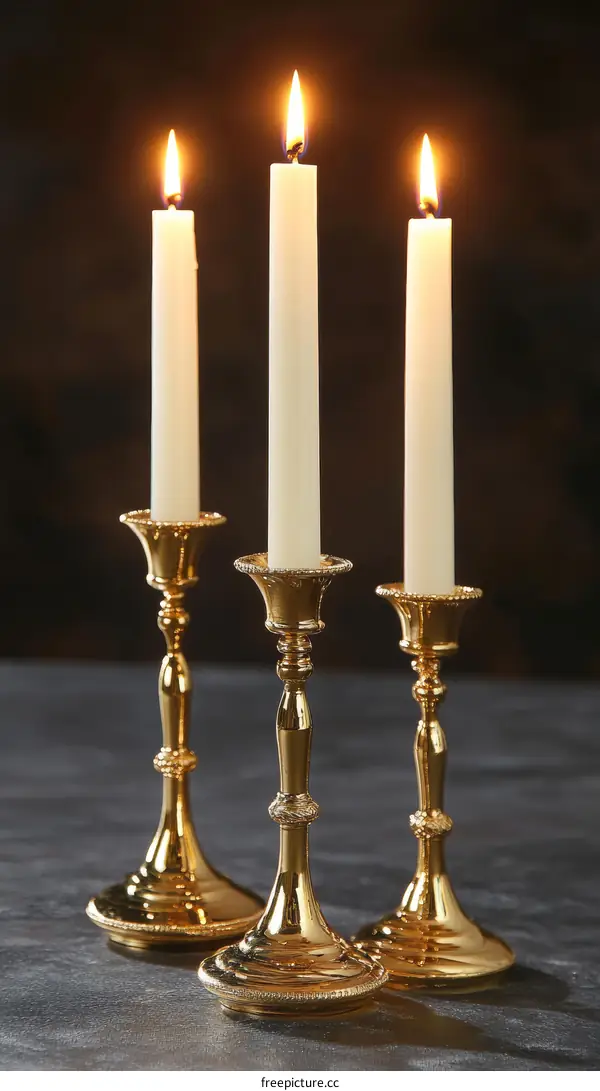 Three Gold Candlesticks with White Candles