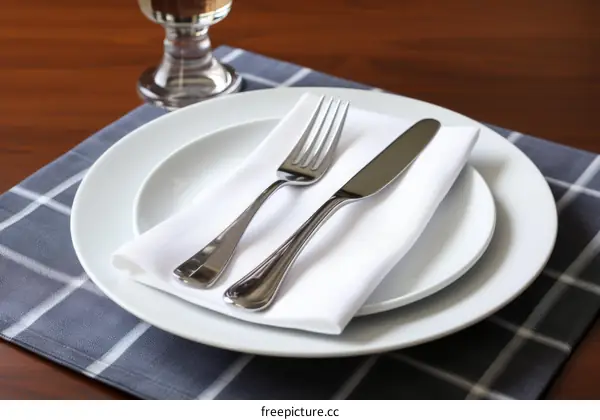 Table Setting with Silverware, Wine Glass, Napkin on a White Tablecloth