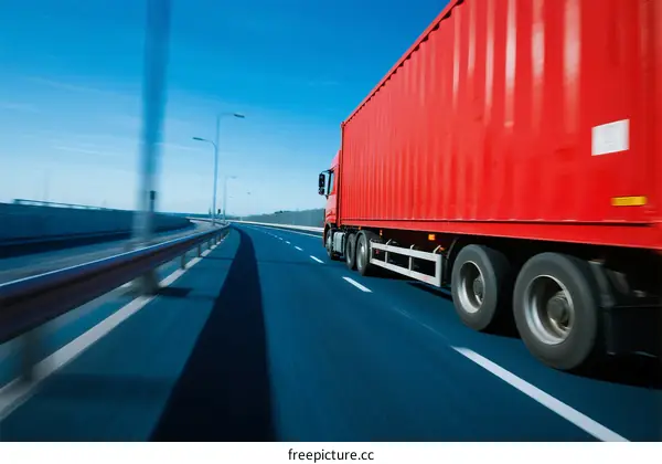 Red Semi-Truck Moving Fast on Highway with Clear Blue Sky