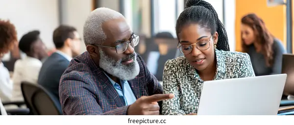 African American Man and Woman Working on a Laptop in an Office Setting