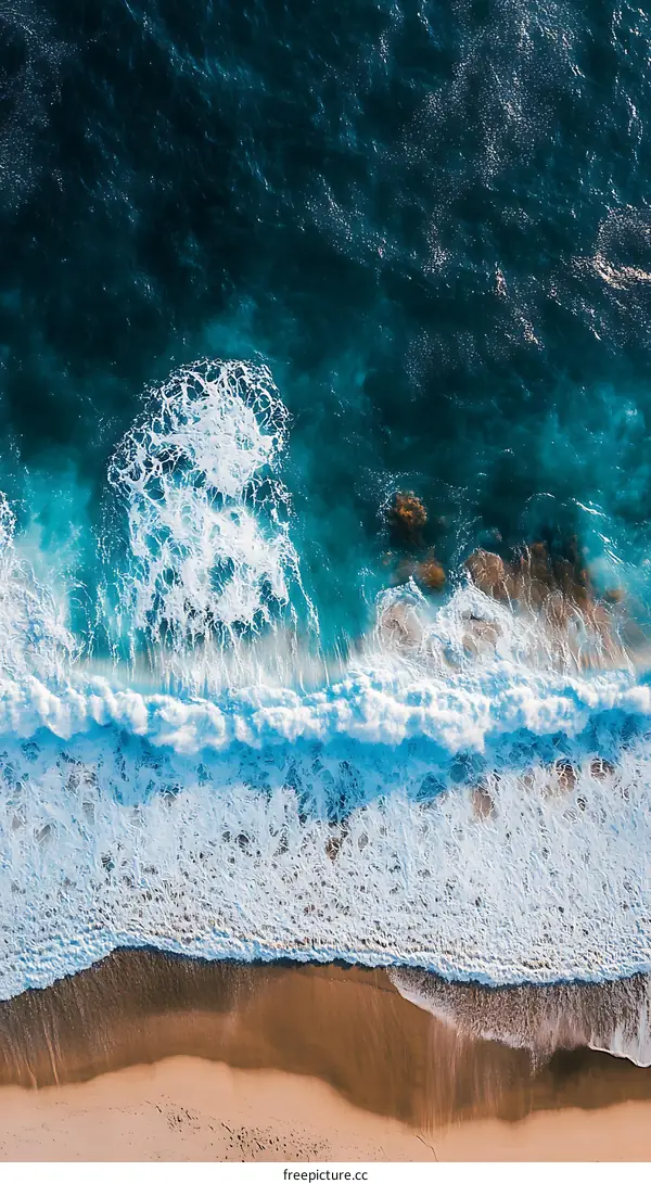 Aerial View of Ocean Waves Crashing on Sandy Beach