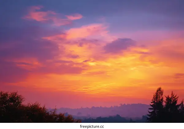 Vibrant Sunset Sky Over Misty Hills
