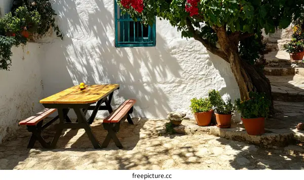 Outdoor Wooden Picnic Table in a Whitewashed Courtyard