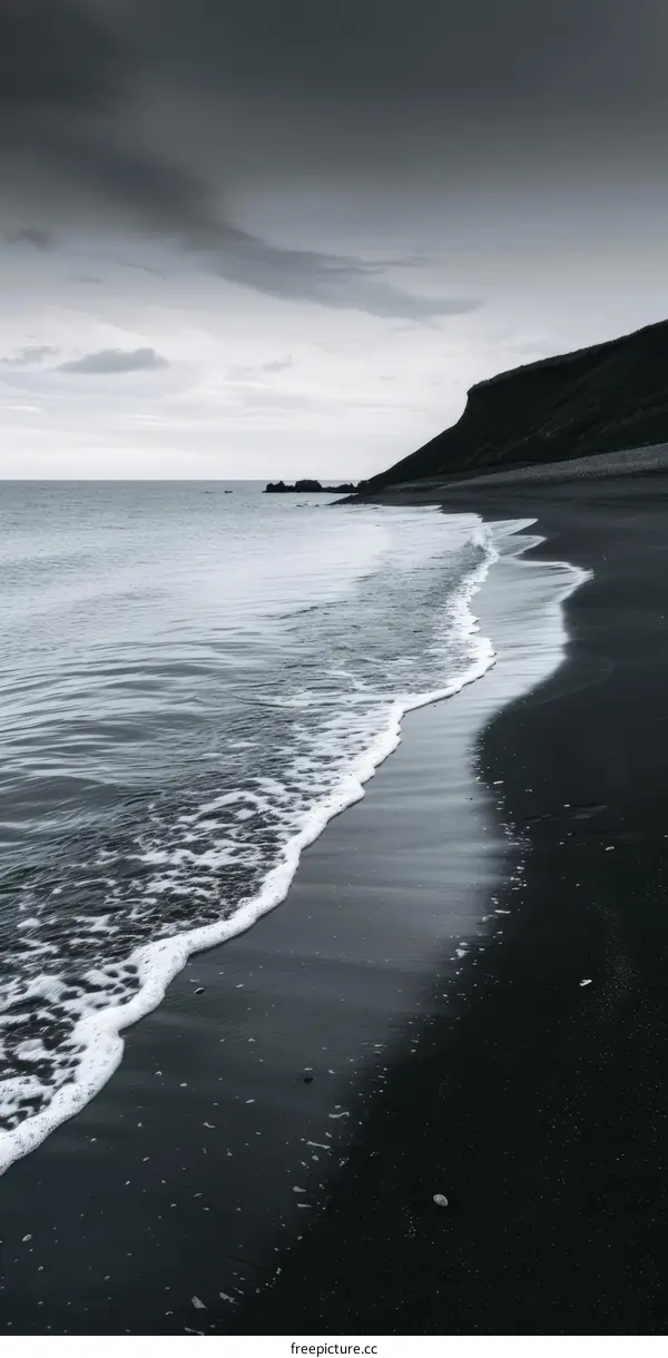 Black Sand Beach with Dramatic Waves and Cloudy Sky
