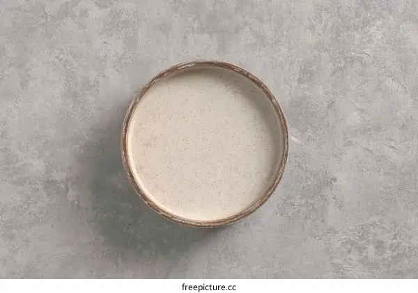 Empty light beige bowl on gray textured surface