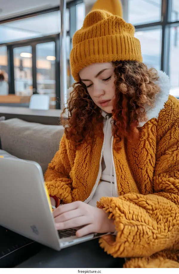 Woman Working on Laptop While Wearing Yellow Fuzzy Jacket