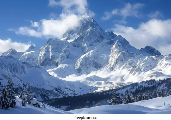 A majestic snow-capped mountain peak rising above a vast snowy landscape