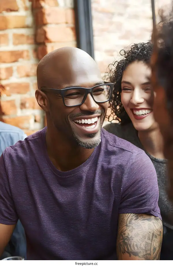 Smiling Man with Glasses Wearing a Purple T Shirt and Tattoo