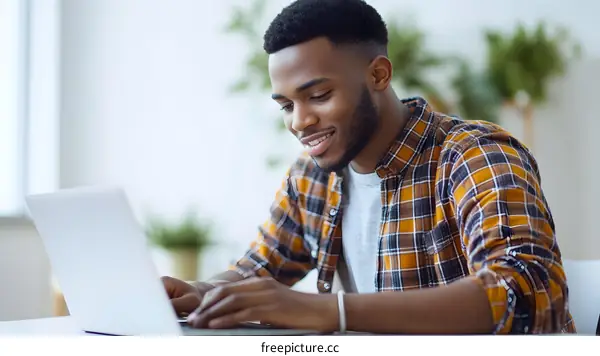 Smiling African American Man Working On Laptop