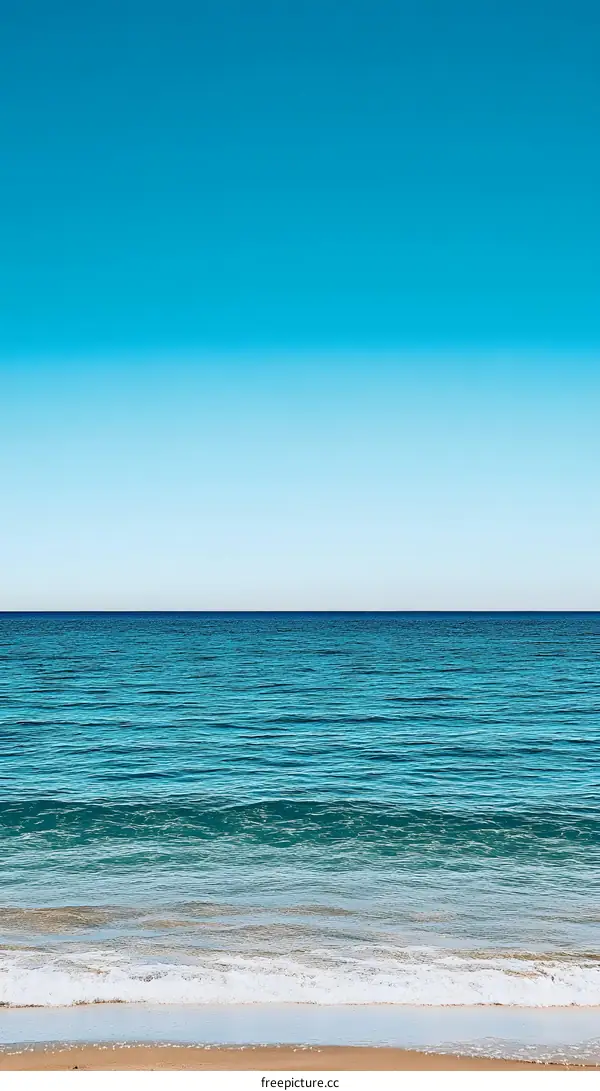 Tranquil Blue Ocean and Sandy Beach Under a Clear Sky