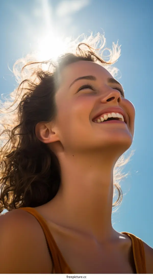Portrait of a beautiful young woman smiling with her eyes closed and her face turned up towards the sun