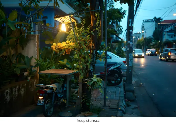 Streetside Table and Motorbike with City Lights in the Background