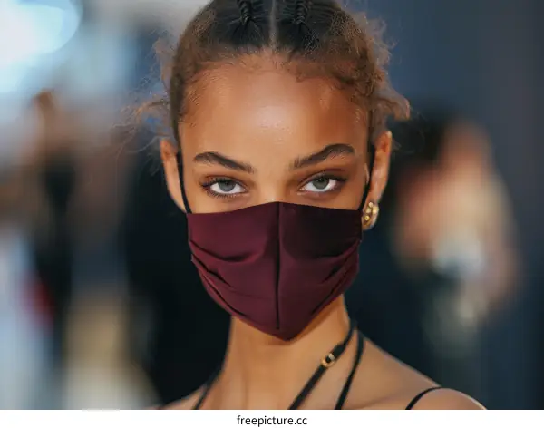 A model wearing a burgundy face mask