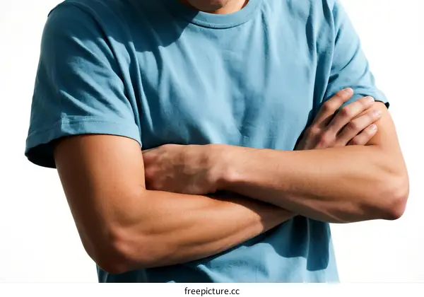 A man in a light blue t-shirt with arms crossed