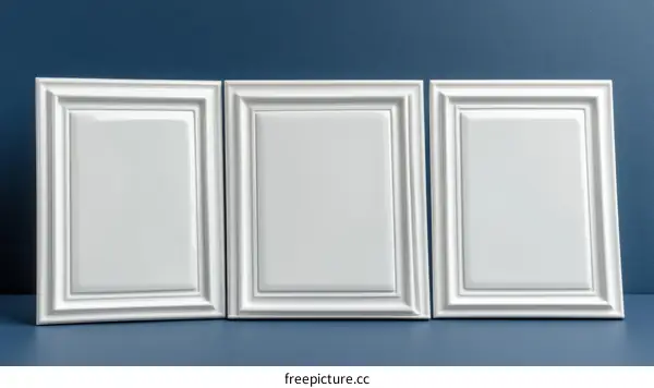 Three Elegant White Picture Frames on a Dark Blue Background