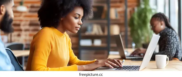 African American Woman Working on Laptop in Modern Office