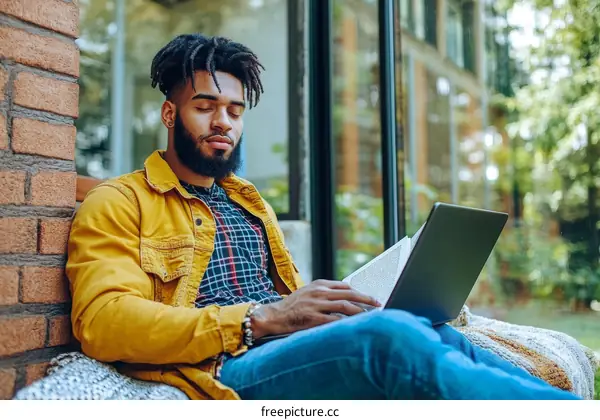 Young Black Man Working Outdoors with Laptop