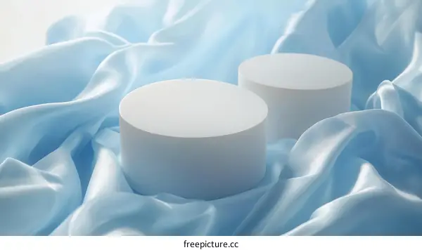 Elegant Light Blue Silk Fabric with White Display Cylinders