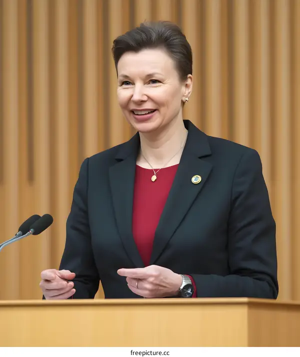 Woman in a Black Blazer Delivering a Speech at a Podium