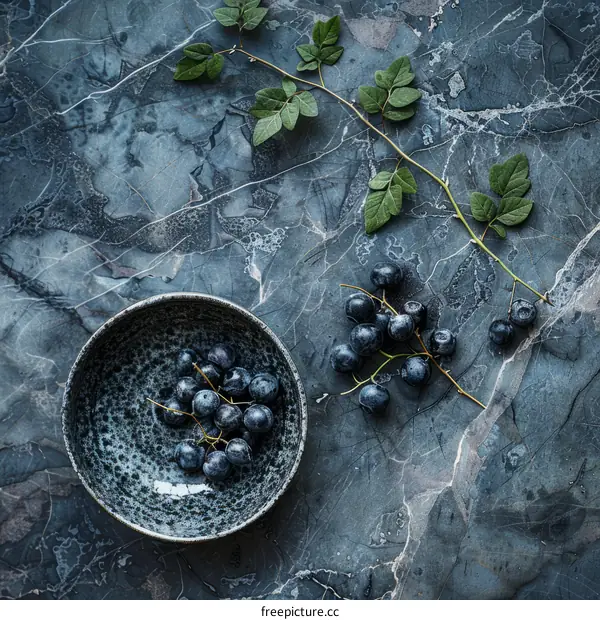 Refreshing Blueberries in a Bowl with Vibrant Green Leaves on a Marble Background