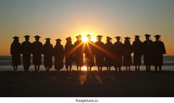 A group of diverse college graduates celebrate their commencement on the beach at sunset