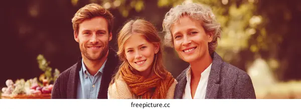 Three smiling people outdoors in natural setting